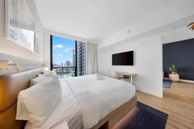 a white bedroom with a large bed and a window at 2 bedroom Condo at Gale Downtown Pool Gym SPA in Miami