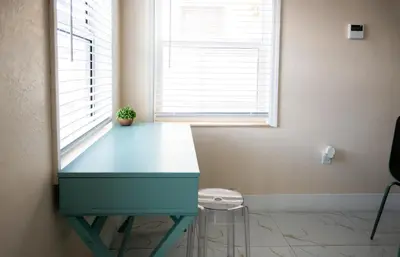 a blue desk in a room with a window at Central Getaway in Little Havana Near Airport, Wynwood, Calle 8 Brickell, Coral Gables and more , Fenced parking in Miami