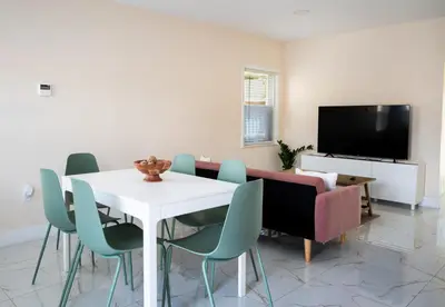 a dining room with a table and chairs and a tv at Central Getaway in Little Havana Near Airport, Wynwood, Calle 8 Brickell, Coral Gables and more , Fenced parking in Miami