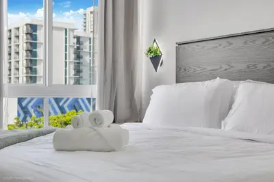 a white bed with two rolls of towels on it at Lux 3BR City-View Retreat in Hollywood, 4th Floor in Hollywood