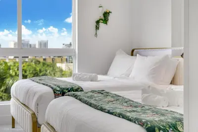 two beds in a room with a window at Lux 3BR City-View Retreat in Hollywood, 4th Floor in Hollywood