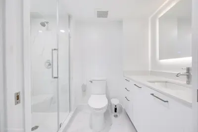 a white bathroom with a shower and a toilet at Lux 3BR City-View Retreat in Hollywood, 3rd Floor in Hollywood