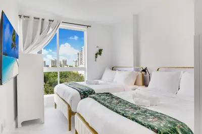 two beds in a room with a window at Lux 3BR City-View Retreat in Hollywood, 3rd Floor in Hollywood