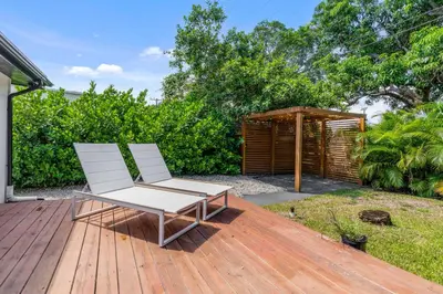 two white chairs sitting on a wooden deck at Casa Siesta- Hot tub Home Gym and Modern Design in Miami