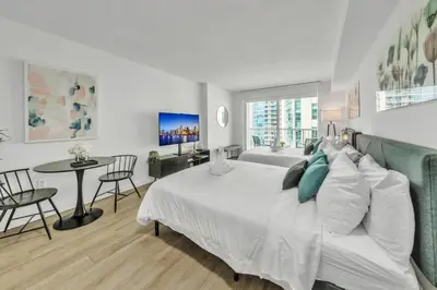 a bedroom with a white bed and a table and chairs at Marvelous Studio in Brickell Free Parking in Miami