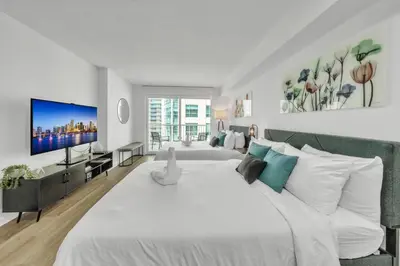 a bedroom with a large white bed and a flat screen tv at Marvelous Studio in Brickell Free Parking in Miami