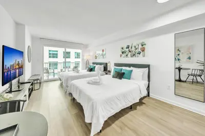 a hotel room with two beds and a flat screen tv at Marvelous Studio in Brickell Free Parking in Miami