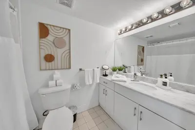 a white bathroom with a toilet and a sink at Marvelous Studio in Brickell Free Parking in Miami