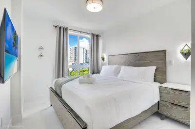 a white bedroom with a large bed and a window at Lux 3BR City-View Retreat in Hollywood, 2nd Floor in Hollywood