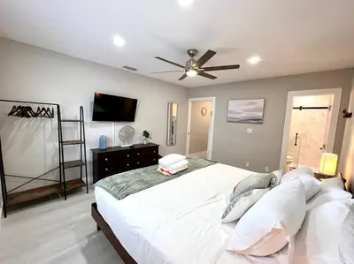 a bedroom with a large bed with a ceiling fan at 1 Block from the Beach 2BR 2BA Newly Renovated in Fort Lauderdale