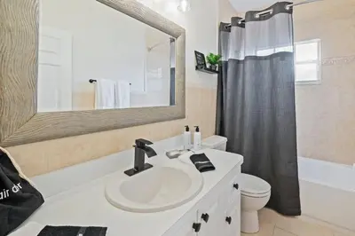 a bathroom with a sink and a toilet and a mirror at Daiquiri in Dania Beach