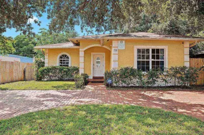 a small yellow house with a brick driveway at Daiquiri in Dania Beach