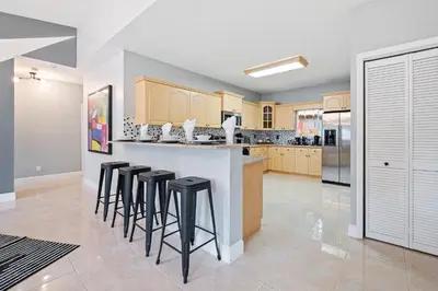 a kitchen with a bar with stools in it at Daiquiri in Dania Beach