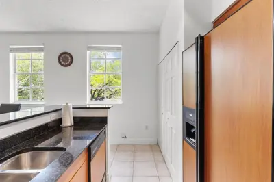 a kitchen with a sink and a refrigerator at Bayside Townhome - Private Beach Access, Pool and Hot Tub, Free Parking in Golden Isles