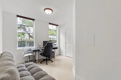 an empty living room with a couch and a desk at Bayside Townhome - Private Beach Access, Pool and Hot Tub, Free Parking in Golden Isles