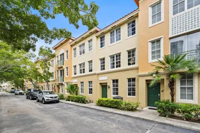 an apartment building with cars parked on the street at Bayside Townhome - Private Beach Access, Pool and Hot Tub, Free Parking in Golden Isles