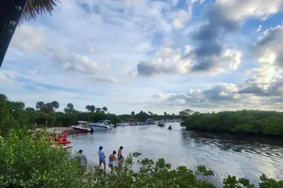 people standing on the shore of a river with boats at Coastal Haven 5 Min to Beach, Patio, BBQ in Dania Beach