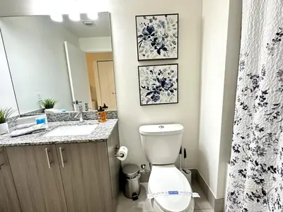 a bathroom with a toilet and a sink and a mirror at Doral Studio with Fabulous View in Miami