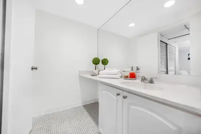 a white bathroom with a sink and a mirror at Oceanfront Luxury Condo with Stunning Views and Resort Amenities in Hollywood
