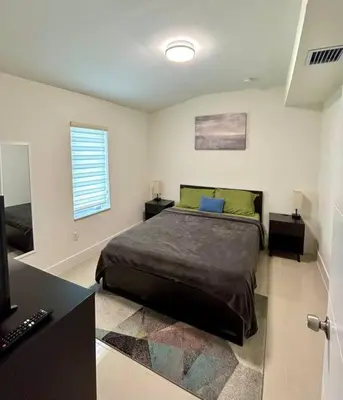 a bedroom with a large bed and a window at Modern Home w Jacuzzi Near Wynwood-Design District-MIA Airport in Miami