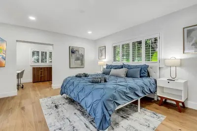 a bedroom with a large bed with blue sheets at Villa Oasis with Heated Pool,Sauna, BBQ and Pool Table in Pinecrest