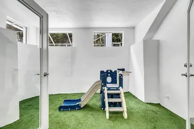 a play room with a slide and green carpet at Villa Oasis with Heated Pool,Sauna, BBQ and Pool Table in Pinecrest
