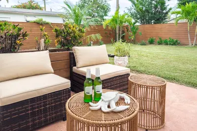 a patio with two chairs and two bottles of wine at Imagine Residence in Hallandale Beach