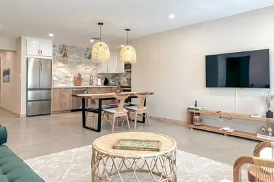a living room with a table and a kitchen at Imagine Residence in Hallandale Beach