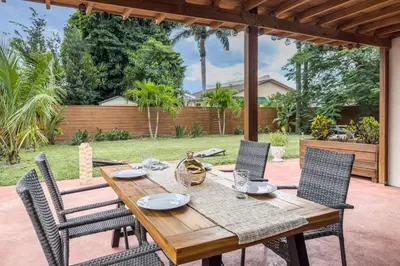 a wooden table and chairs on a patio at Imagine Residence in Hallandale Beach