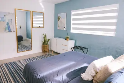 a bedroom with a large bed and a mirror at Beach Oasis King Bed & Near Hollywood beach in Hollywood