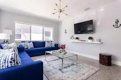 a living room with a blue couch and a table at Beach Oasis King Bed & Near Hollywood beach in Hollywood