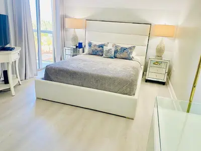 a white bedroom with a bed and a window at OCEAN VIEW 1BR 2BA BEACH CONDO Parking in Miami Beach
