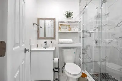 a white bathroom with a toilet and a shower at Nice,Stylish King Bed Studio in Miami Gardens