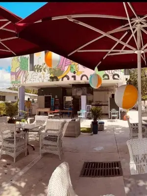 a patio with tables and chairs and an umbrella at Miami Design District in Miami