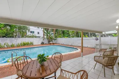 a patio with a table and chairs and a pool at Beach Home Estate I Pool & Ocean in Fort Lauderdale