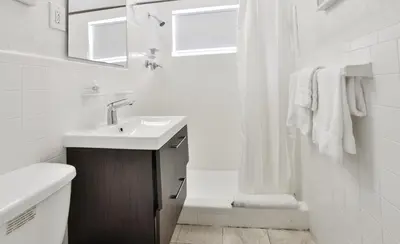 a white bathroom with a sink and a shower at Krymwood Flats Wynwood in Miami