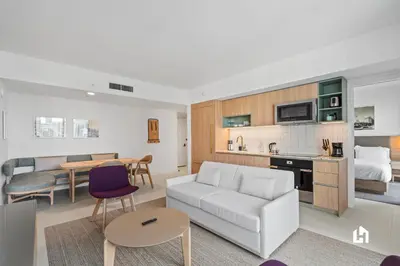 a living room with a couch and a bedroom at Stylish Apartments with Partial Ocean Views in Downtown! in Miami