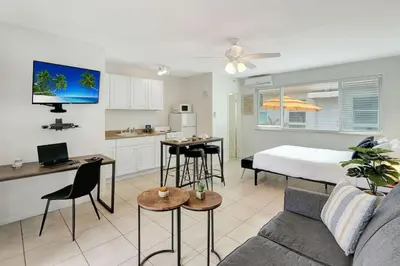 a living room with a couch and a bed and a kitchen at Sunset Bliss Hollywood Seaside Studio Retreat in Hollywood
