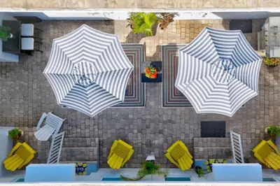 three white and blue umbrellas on a patio at Hollywood Beach Escapade Studio with Free Parking in Hollywood