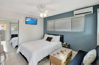 a bedroom with a large bed and a couch at Coastal Comfort Hollywood Studio Retreat in Hollywood