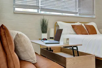 a bedroom with a bed and a table with a laptop on it at Beachside Bliss Hollywood Studio in Hollywood