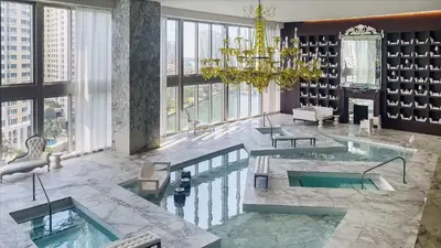 a hotel lobby with a pool and a chandelier at Large Suites in Hotel W with bay views in Miami