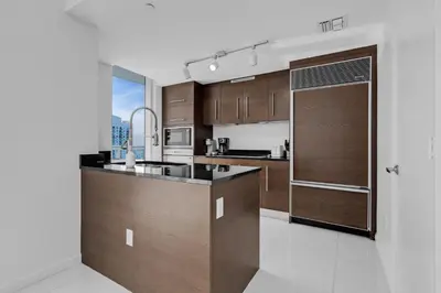 a kitchen with wooden cabinets and a refrigerator at Large Suites in Hotel W with bay views in Miami