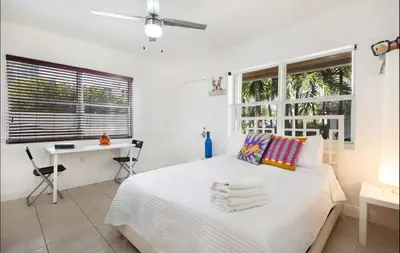 a white bedroom with a bed and a desk at B11 Design District Studio Short drive 2 beach in Miami