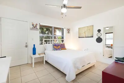 a white bedroom with a white bed and a window at B11 Design District Studio Short drive 2 beach in Miami