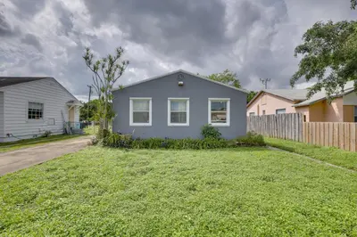 a blue house in a yard with a fence at 3 Mi to Beach Quaint Home with Patio in Hollywood in Hollywood