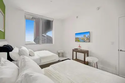 a white room with two beds and a table at Penthouse Sky Suite - 2BDR2BTH - Private Rooftop Terrace in Hallandale Beach