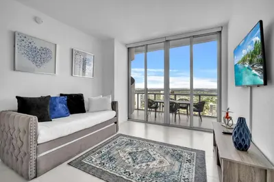 a living room with a couch and a large window at Penthouse Sky Suite - 2BDR2BTH - Private Rooftop Terrace in Hallandale Beach