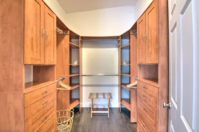 a walk in closet with wooden cabinets and a stool at Gorgeous Las Olas - Heated Pool, Close to Beach in Fort Lauderdale