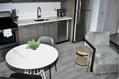 a kitchen with a table and a white table and chairs at The Bayfront III in Miami